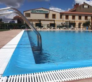 a swimming pool with a metal hand rail in the water at EL DELFÍN VERDE in Villarente