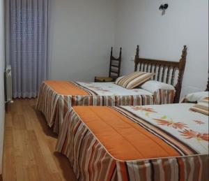 twee bedden in een kamer met houten vloeren bij EL DELFÍN VERDE in Villarente