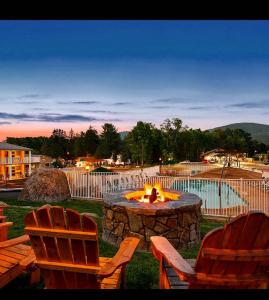 twee stoelen en een vuurplaats in een tuin bij Super 8 by Wyndham Lake George/Downtown in Lake George