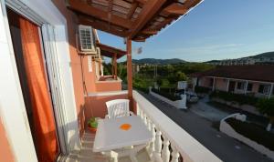 a balcony with a white bench and a view of a street at Panagiotis Studios in Laganas