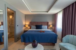 a bedroom with a blue bed and a chair at Malta Bosphorus Hotel in Istanbul