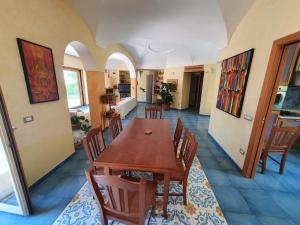 una sala da pranzo con tavolo e sedie in legno di Exclusive Luxury Villa in Forio a Ischia