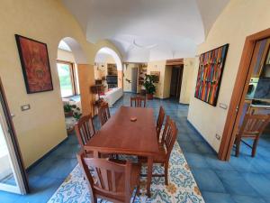 Un comedor con mesa y sillas de madera. en Exclusive Luxury Villa in Forio, en Isquia