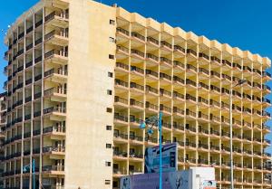 un edificio alto con balcones a un lado. en Semiramis Hotel Royal Palace, en Marsa Matruh