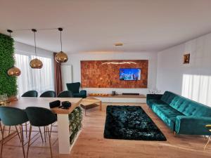 a living room with a green couch and a table at Cliché Luxury Apartment in Braşov