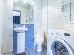 une salle de bain avec une machine à laver et un lave-linge dans l'établissement Willa Ewka, à Kościelisko 7 autres photos