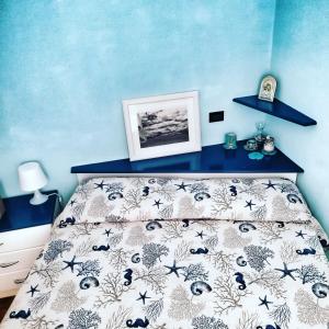 モンテ・アルジェンターリオにあるMy Little Houseの青い壁のベッドルーム1室(ベッド1台付)