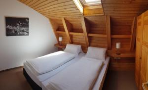 a bedroom with two beds in a wooden room at Landhaus Scherl in Seefeld in Tirol