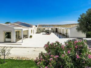 una casa con un patio con flores rosas en Addauro Resort, en Siracusa