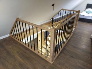 a wooden staircase in a room with a bed at VIP Apartament Sosnówka in Sosnówka
