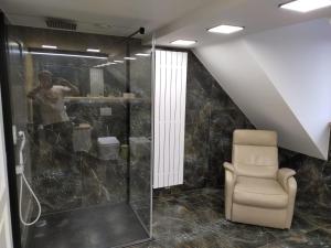 a bathroom with a shower and a chair at VIP Apartament Sosnówka in Sosnówka +24 photos