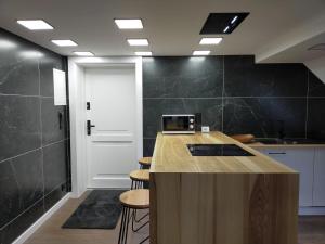 a kitchen with a counter with stools and a door at VIP Apartament Sosnówka in Sosnówka