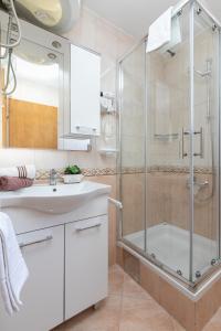 ein Bad mit einer Dusche und einem Waschbecken in der Unterkunft Apartments Barba in Tučepi