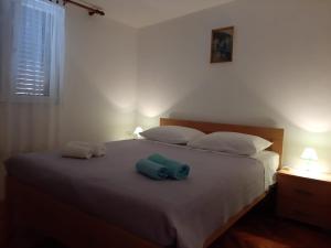 una camera da letto con un letto e due asciugamani di Apartmani Marija a Grebaštica