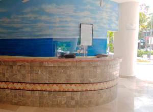 a lobby with a reception desk in a building at Calinda Beach Acapulco in Acapulco