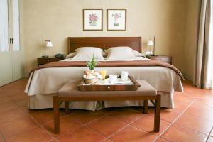 a bedroom with a bed and a table with a tray of food at Bremon Boutique Hotel by Duquessa Hotel Collection in Cardona