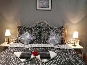 ein Bett mit Kissen und einer roten Rose darauf in der Unterkunft Apartments Sven-Marino in Poreč