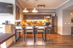 a kitchen with a bar with stools in it at Atlantic Home Azores in Ponta Delgada