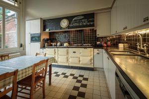 a kitchen with a sink and a table with chairs at Talbot House in Poperinge
