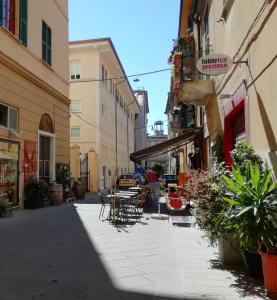un vicolo in una città con tavoli e sedie di Valerie a La Spezia