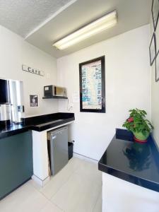 een keuken met zwarte werkbladen in een kamer bij Motel Reno in Tijuana