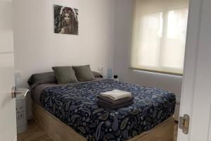 1 dormitorio con 1 cama con edredón azul en Lovely house near the beach, en Calafell