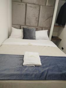 un grande letto con un asciugamano bianco sopra di Hotel Funza Real a Funza
