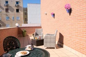 eine Terrasse mit einem Tisch, Stühlen und einer Ziegelwand in der Unterkunft Hotel Sancho in Madrid