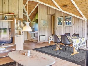 a living room with a table and chairs and a kitchen at 6 person holiday home in Hemmet in Falen