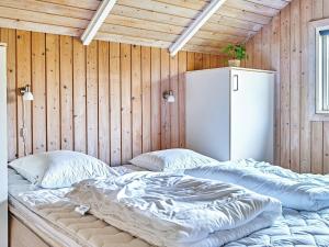 a bed in a room with a wooden wall at 6 person holiday home in Hemmet in Falen
