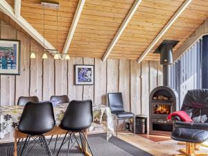 a room with a table and chairs and a fireplace at 6 person holiday home in Hemmet in Falen