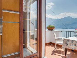 a room with a balcony with a view of the mountains at Wonderful holiday home with swimming pool and lift in Gravedona