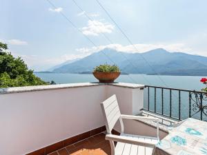 a balcony with a view of the water and mountains at Wonderful holiday home with swimming pool and lift in Gravedona