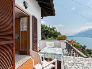 a balcony with a table and chairs and a view of the water at Wonderful holiday home with swimming pool and lift in Gravedona