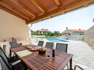 un patio con mesa, sillas y piscina en Tranquil Holiday Home in Labin with Private Swimming Pool, en Labin