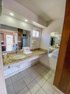 een badkamer met een wastafel en een grote spiegel bij Motel Reno in Tijuana