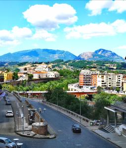 uma rua da cidade com edifícios e montanhas ao fundo em Anamonì Bed and Relax em Benevento