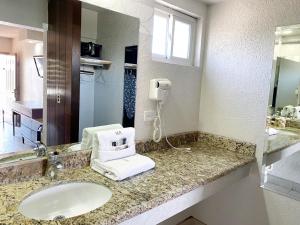 een badkamer met een wastafel en een haardroger op een aanrecht bij Motel Reno in Tijuana