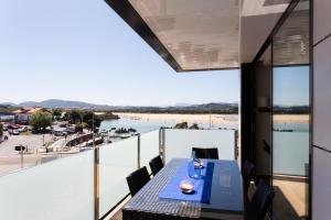 
a dining room table with a view of the ocean at Apartamentos Playa De Los Barcos in Isla
