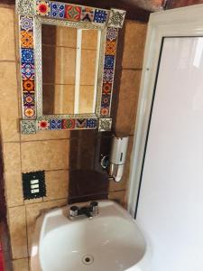 La salle de bains est pourvue d'un lavabo blanc et d'un miroir. dans l'établissement CABAÑAS ZIRAHUEN LOS ANGELES, à Zirahuén