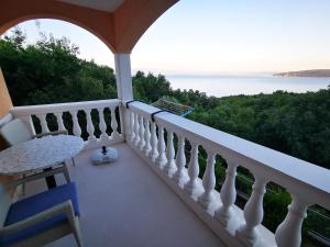 a balcony with a table and a view of the water at Apartments Solte in Mošćenice