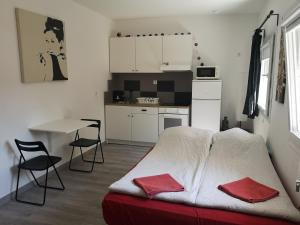 a bedroom with a bed and a table and a kitchen at Madrid Green in Villaviciosa de Odón