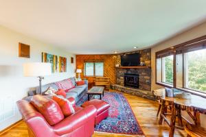a living room with a leather couch and a fireplace at Crest 100E in Sugar Mountain