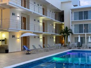 a hotel with a swimming pool in front of a building at Hotel Huatulco Máxico in Santa Cruz Huatulco