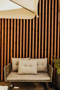 a wicker bench sitting in front of a wall at O Cantinho dos Cabrais in Inguias