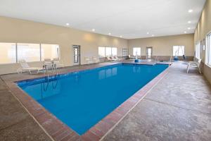 - une grande piscine d'eau bleue dans un bâtiment dans l'établissement La Quinta Inn & Suites by Wyndham Durant, à Durant