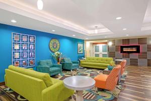 un vestíbulo con muebles verdes y una pared azul en La Quinta by Wyndham Grand Forks en Grand Forks