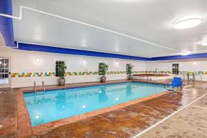 une grande piscine avec de l'eau bleue dans un immeuble dans l'établissement La Quinta by Wyndham Grand Forks, à Grand Forks