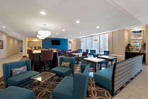 a restaurant with blue chairs and tables and a bar at La Quinta by Wyndham West Monroe in West Monroe