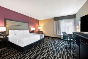 a hotel room with a bed and a flat screen tv at La Quinta by Wyndham West Monroe in West Monroe +25 photos